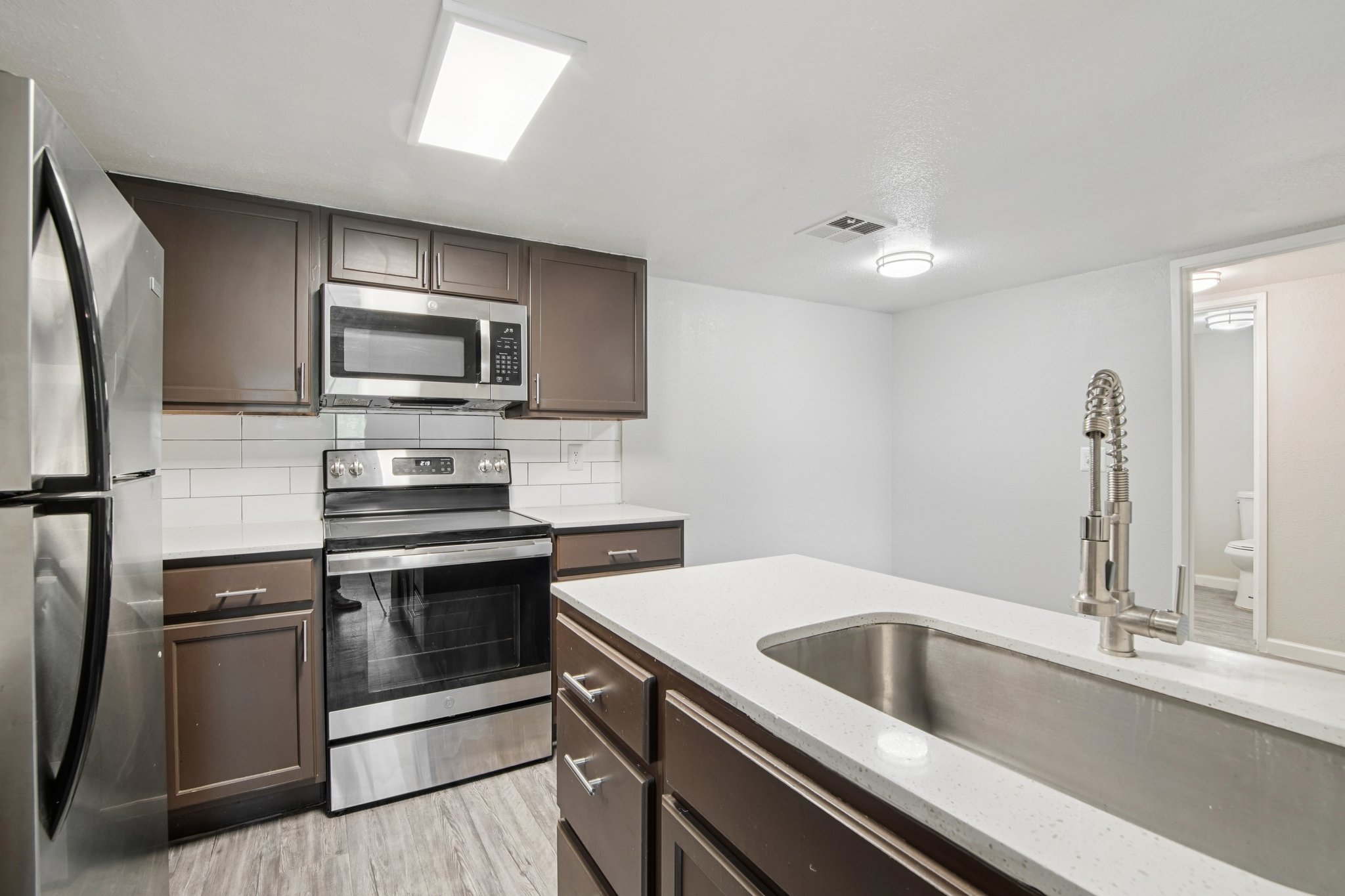 Premium 2-bedroom interior featuring renovated kitchen with brown cabinetry
